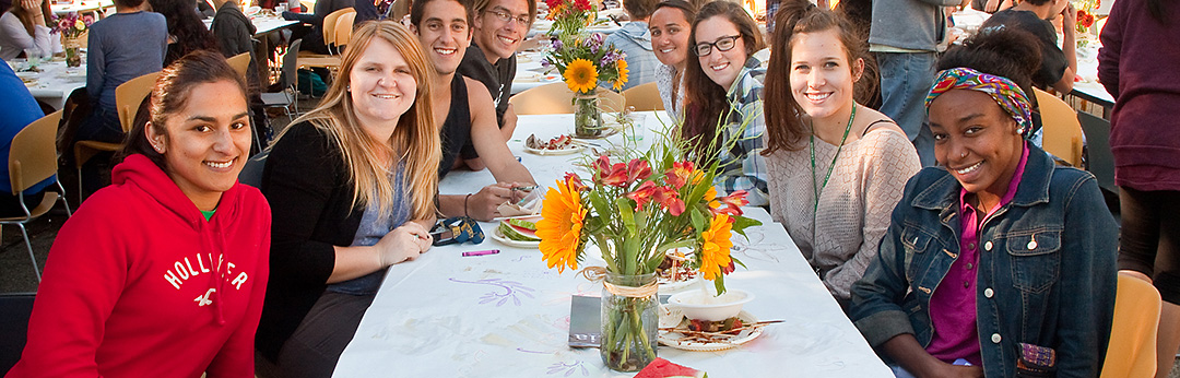 Students sitting at a table smiling at a College Night event