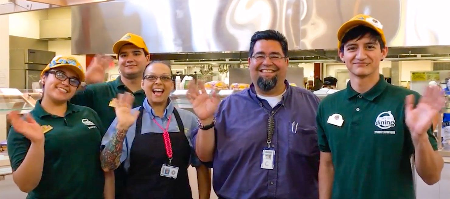 Photo of 5 dining hall staff members waving at the camera